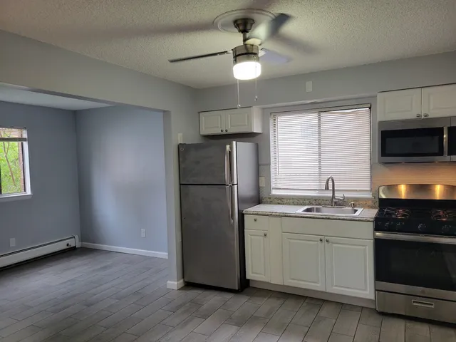 a kitchen with stainless steel appliances granite countertop a refrigerator a sink and a stove