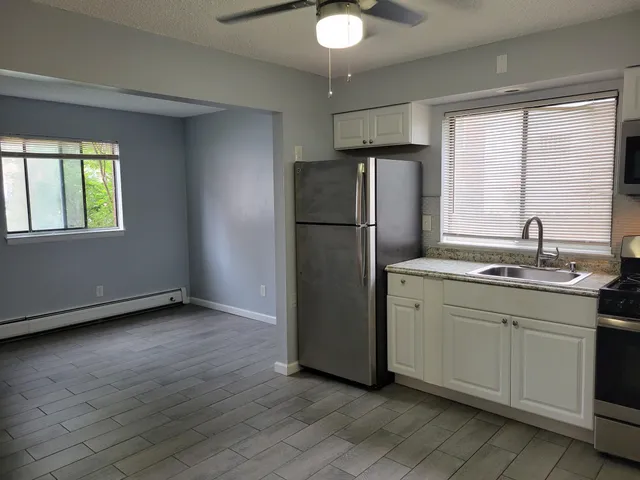 a kitchen with stainless steel appliances a refrigerator and a chandelier