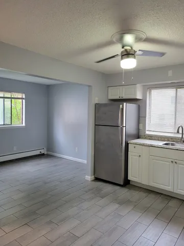 a view of a kitchen with a sink and refrigerator