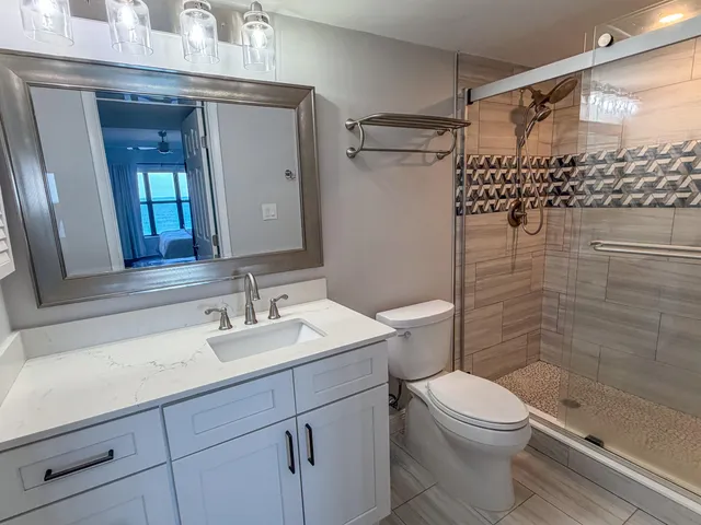 a bathroom with a sink a toilet and shower
