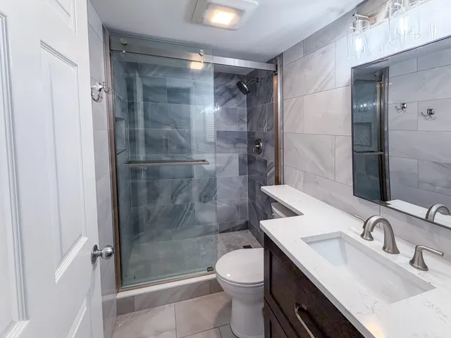 a bathroom with a sink toilet and shower