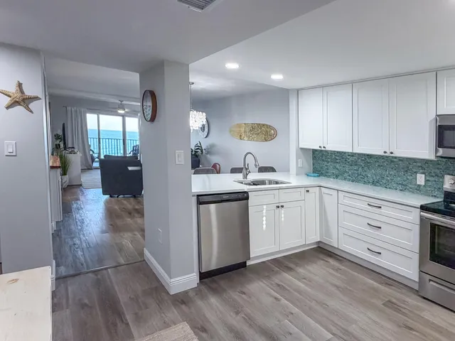 a kitchen with a sink cabinets and wooden floor