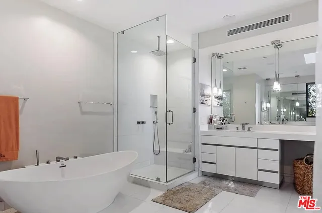 a bathroom with a double vanity sink mirror and shower