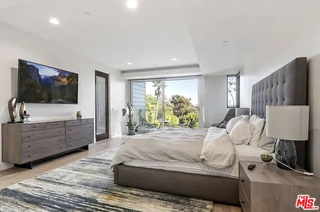 a bedroom with a bed and a flat screen tv