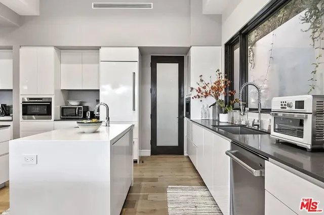 a large white kitchen with stainless steel appliances