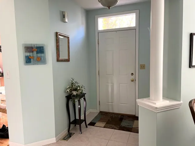 a view of a hallway with bathroom and mirror