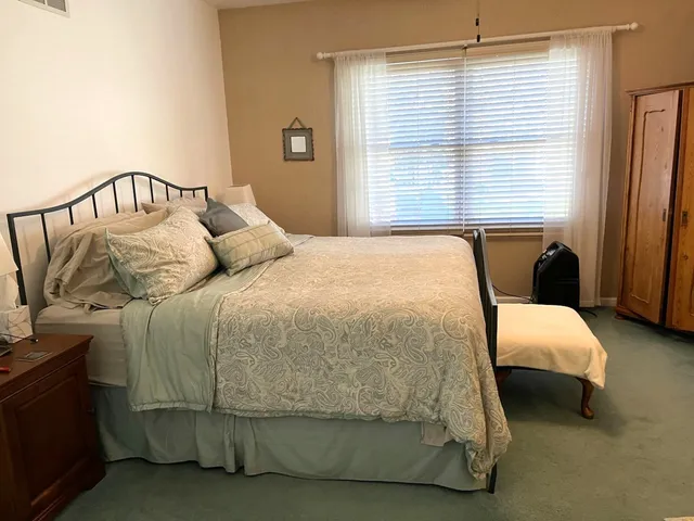 a bedroom with a bed next to a window