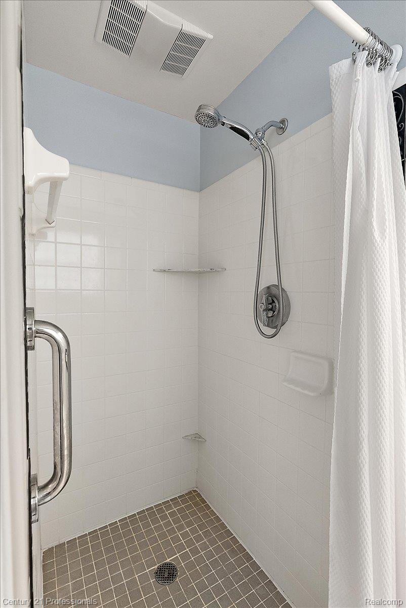 633 Foxhall Road Bloomfield Hills, MI 48304 - Photo 46 of 61 Shower stall with white subway tile walls, a handheld shower fixture, and a tiled floor
