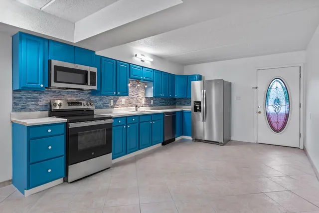 a kitchen with stainless steel appliances granite countertop a refrigerator stove a sink and a microwave oven