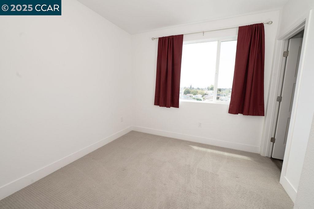 9877 MacArthur Boulevard, Unit E Oakland, CA 94605 - Photo 4 of 13 an empty room with a window
