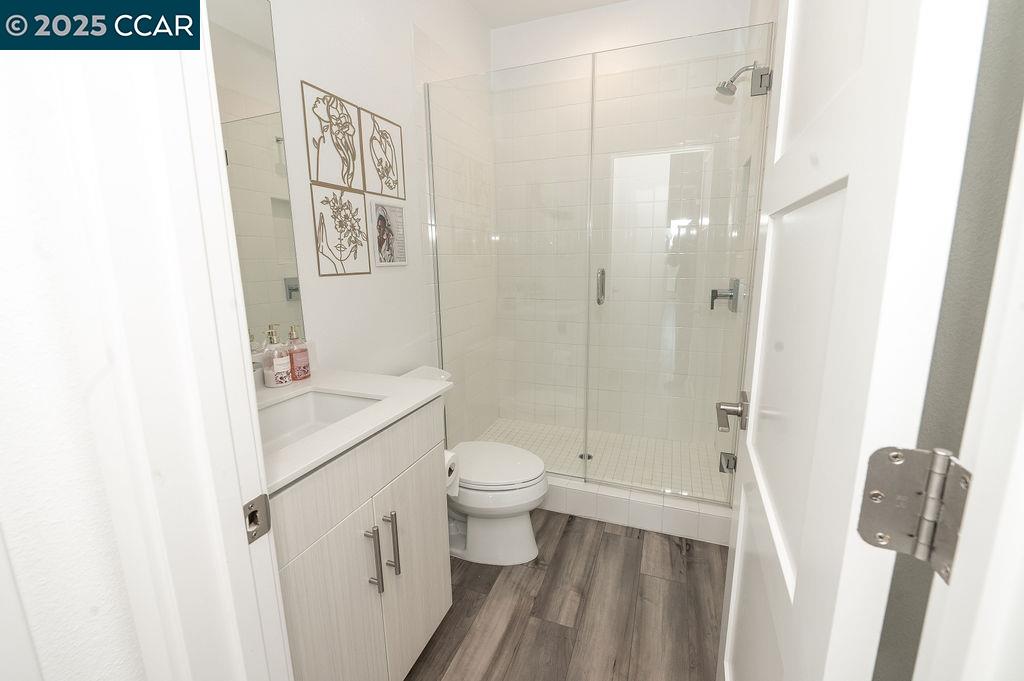 9877 MacArthur Boulevard, Unit E Oakland, CA 94605 - Photo 7 of 13 a bathroom with a sink a toilet and shower