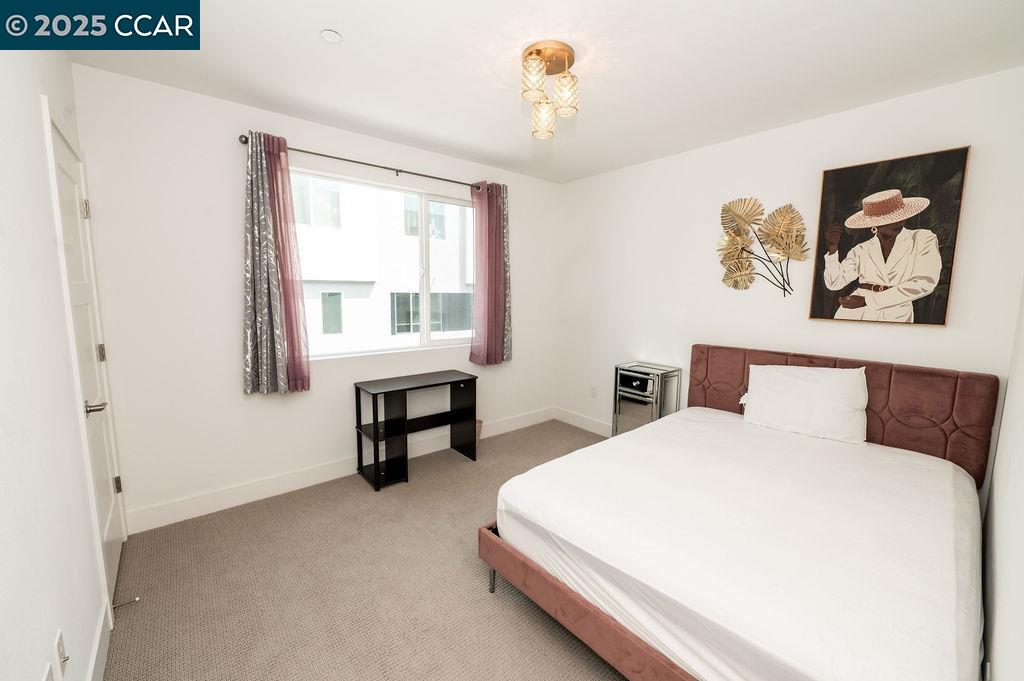 9877 MacArthur Boulevard, Unit E Oakland, CA 94605 - Photo 8 of 13 a bedroom with a bed and a table