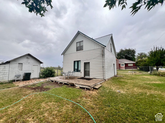 350 West Main Street Emery, UT 84522 - Photo 20 of 28 Back of house with a wooden deck, board and batten siding, a metal roof, and an outbuilding