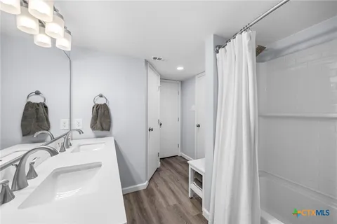 a spacious bathroom with a double vanity sink and a mirror