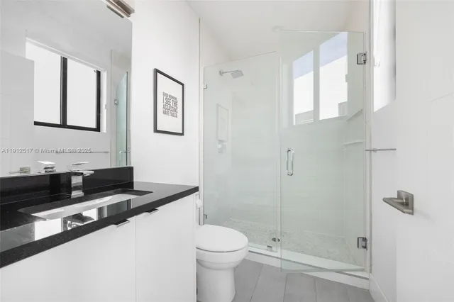 a bathroom with a granite countertop toilet sink and shower