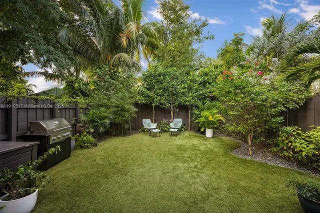 a view of a chair and table in backyard of the house