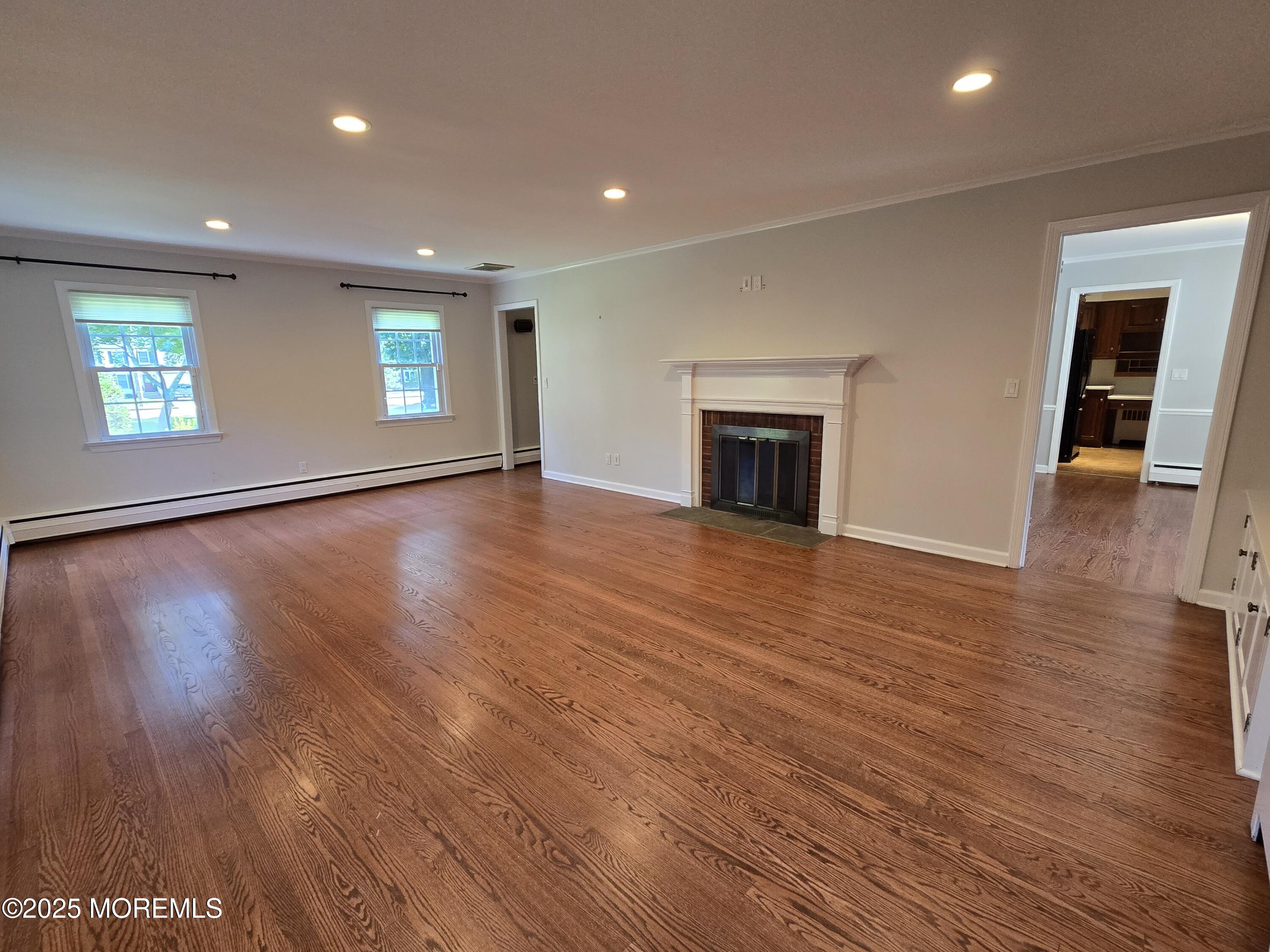 77 Dutch Lane Road Freehold, NJ 07728 - Photo 11 of 50 an empty room with wooden floor fireplace and windows