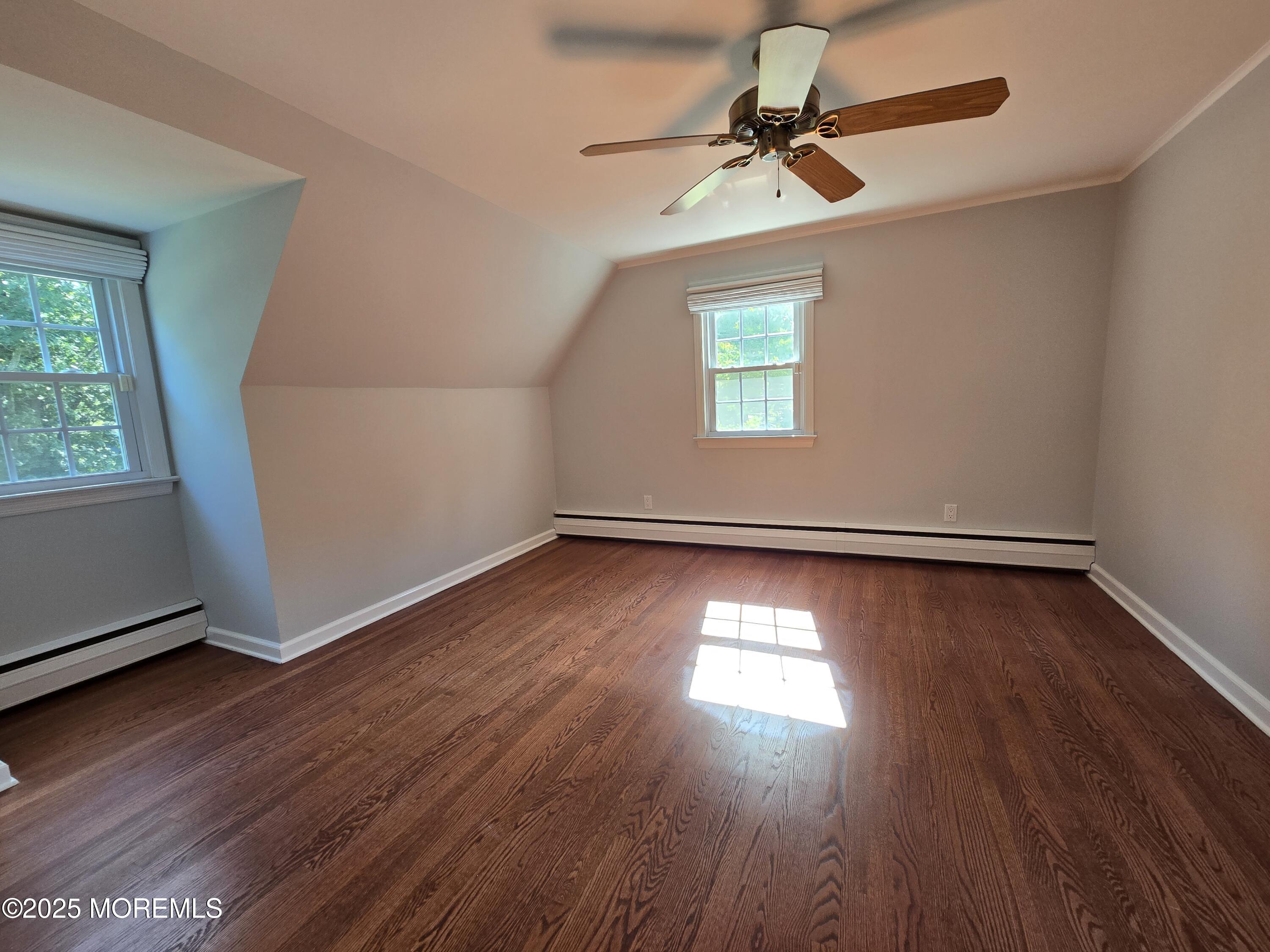 77 Dutch Lane Road Freehold, NJ 07728 - Photo 29 of 50 an empty room with wooden floor chandelier fan and windows