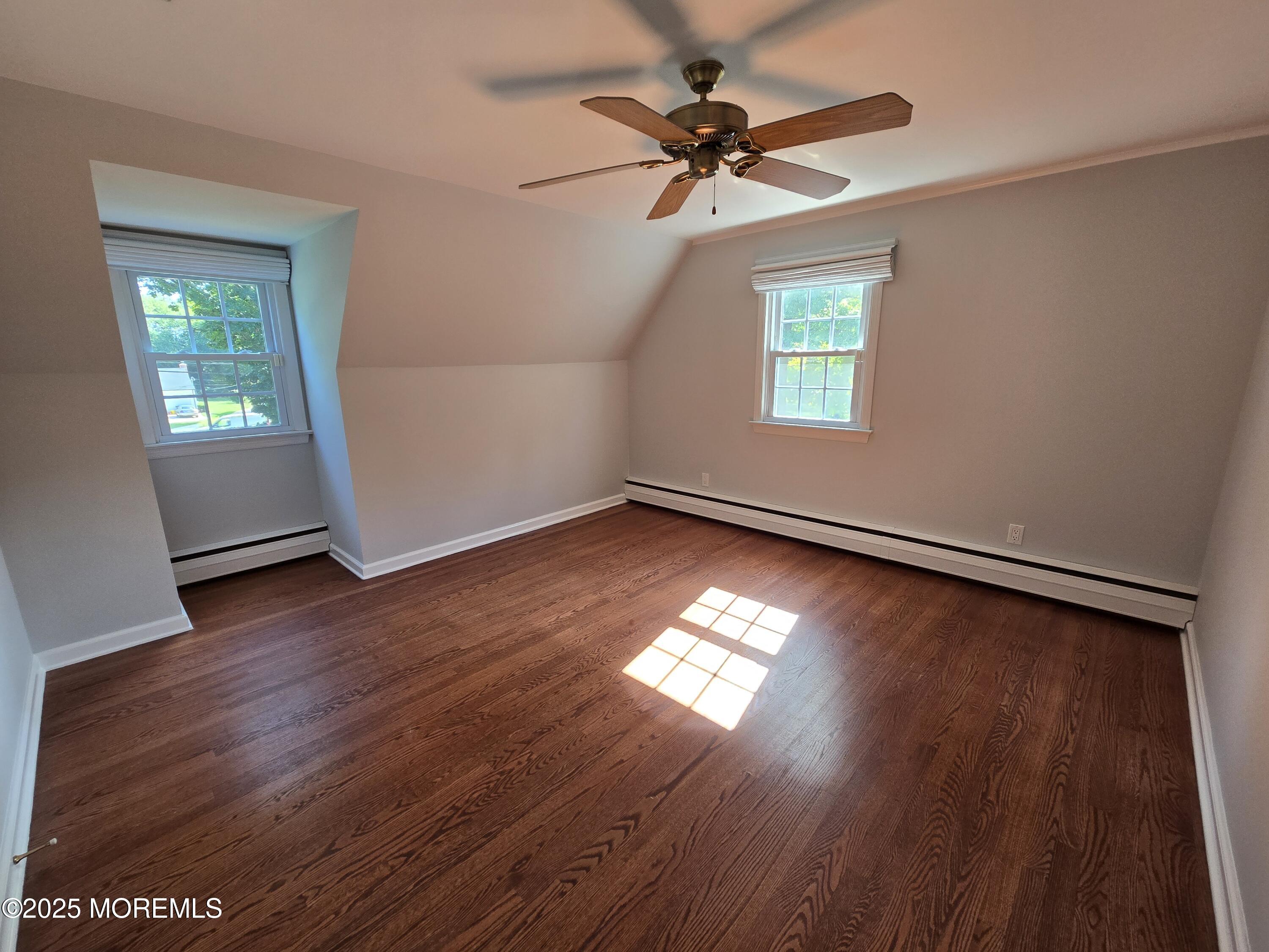 77 Dutch Lane Road Freehold, NJ 07728 - Photo 30 of 50 an empty room with wooden floor chandelier fan and windows