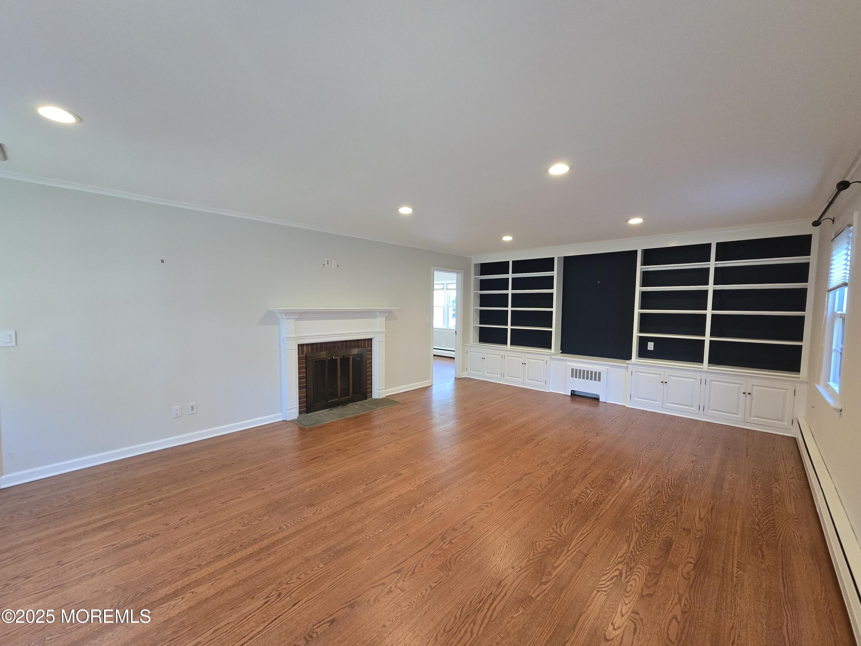 77 Dutch Lane Road Freehold, NJ 07728 - Photo 8 of 50 a view of an empty room with a fireplace and a window