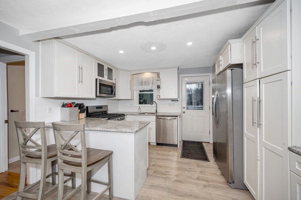 76 Maplewood Drive Townsend, MA 01469 - Photo 7 of 31 a kitchen with stainless steel appliances kitchen island granite countertop a refrigerator and microwave