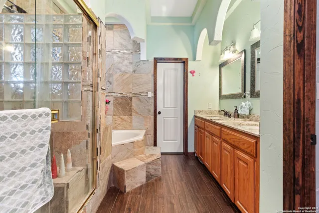a spacious bathroom with a granite countertop shower a sink and a large mirror