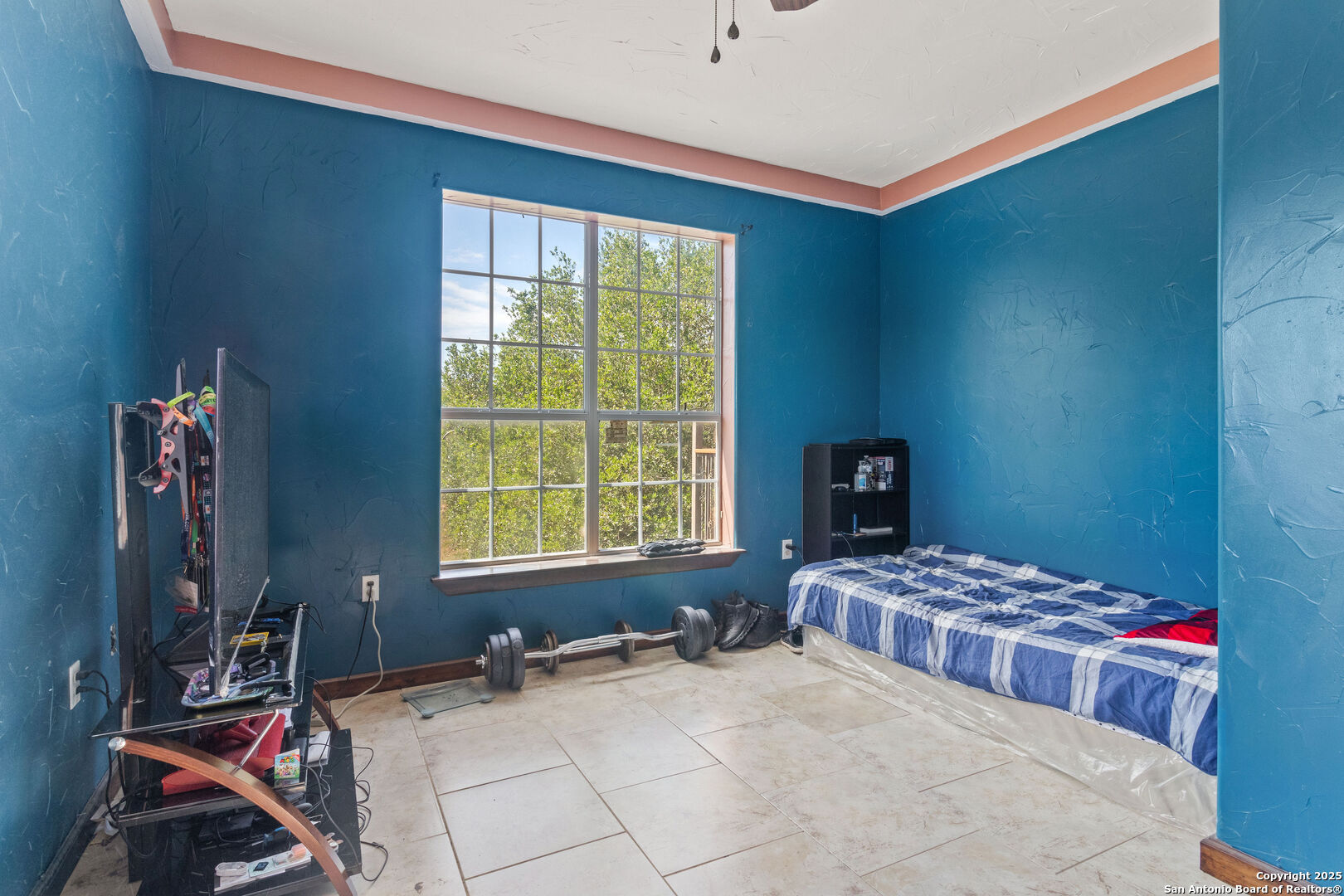 19590 Leal Road San Antonio, TX 78221 - Photo 20 of 41 a bedroom with a bed and a window