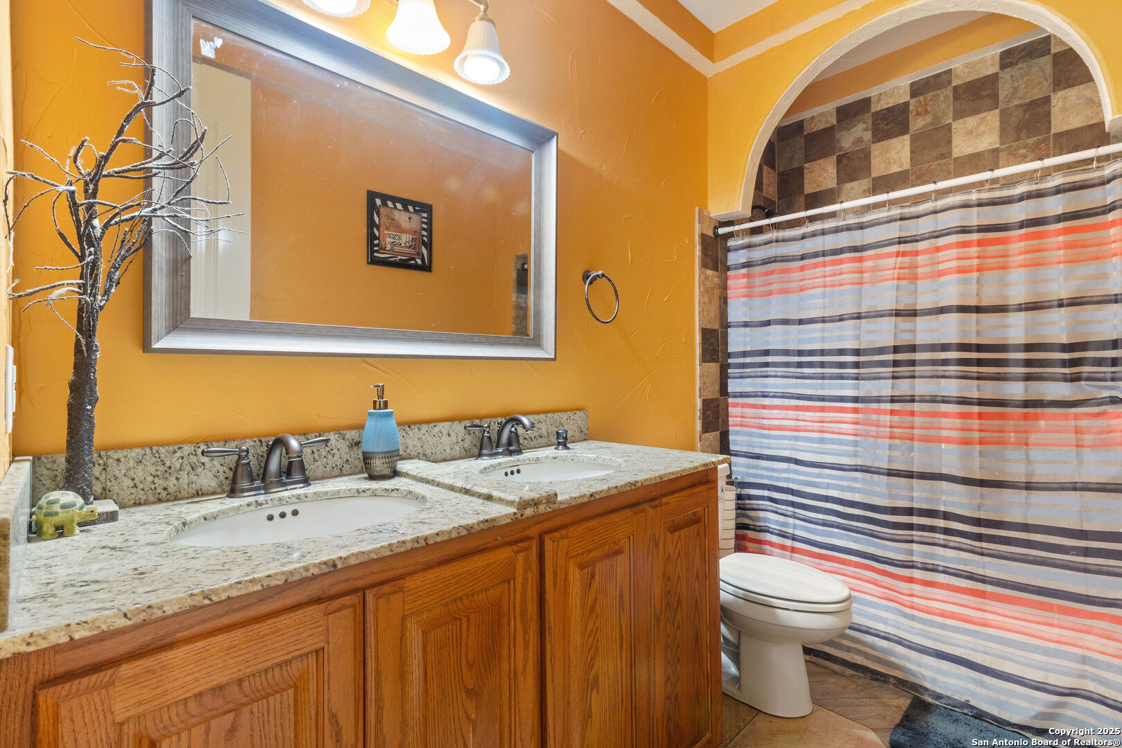 19590 Leal Road San Antonio, TX 78221 - Photo 21 of 41 a bathroom with a sink a toilet and shower curtain