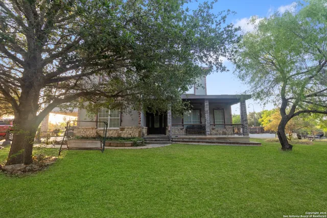 a front view of a house with garden and trees