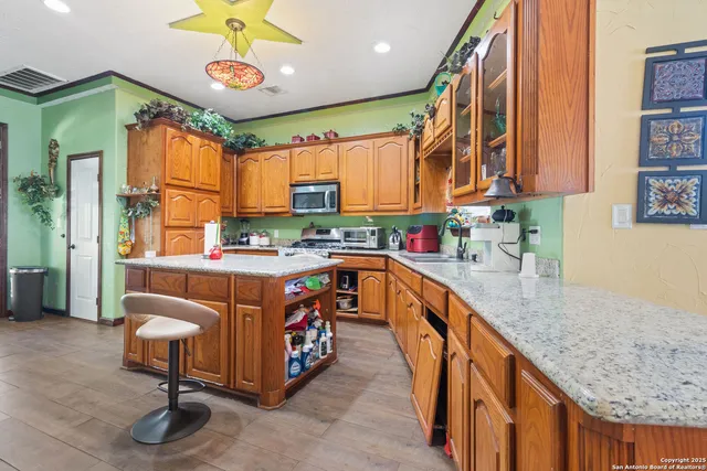 a kitchen with stainless steel appliances granite countertop a sink a stove and a wooden floors