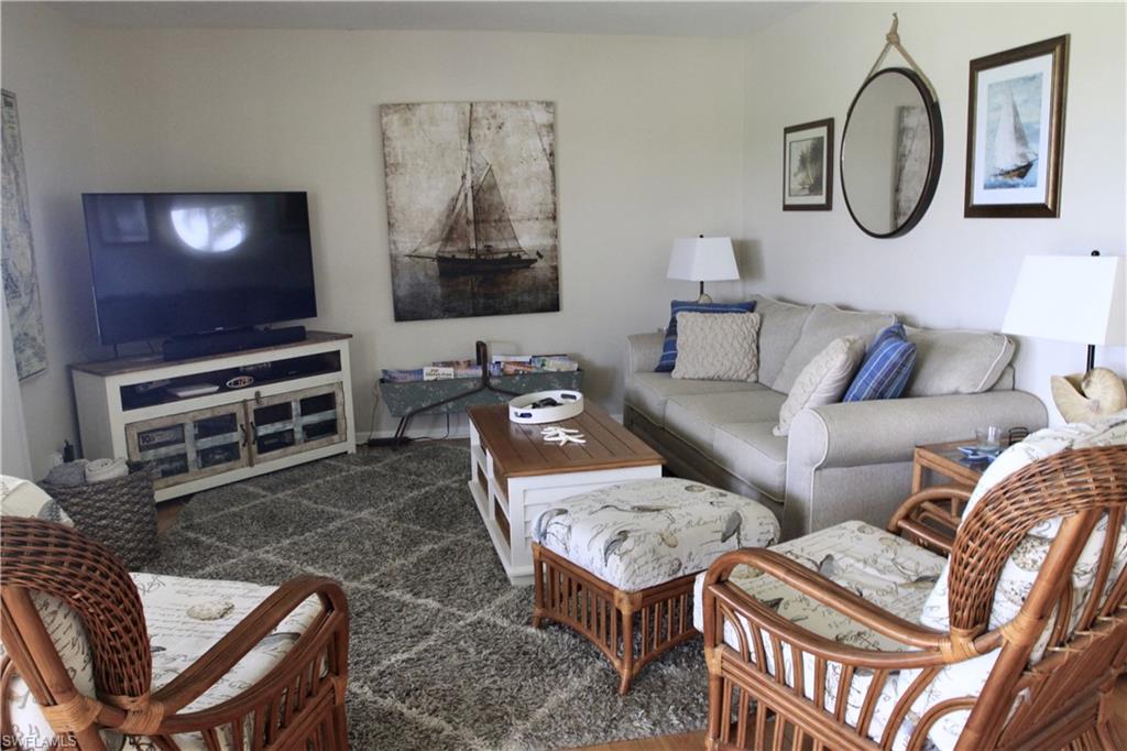 348 Tern Drive, Unit 4 Naples, FL 34112 - Photo 6 of 27 a living room with furniture a flat screen tv and kitchen view