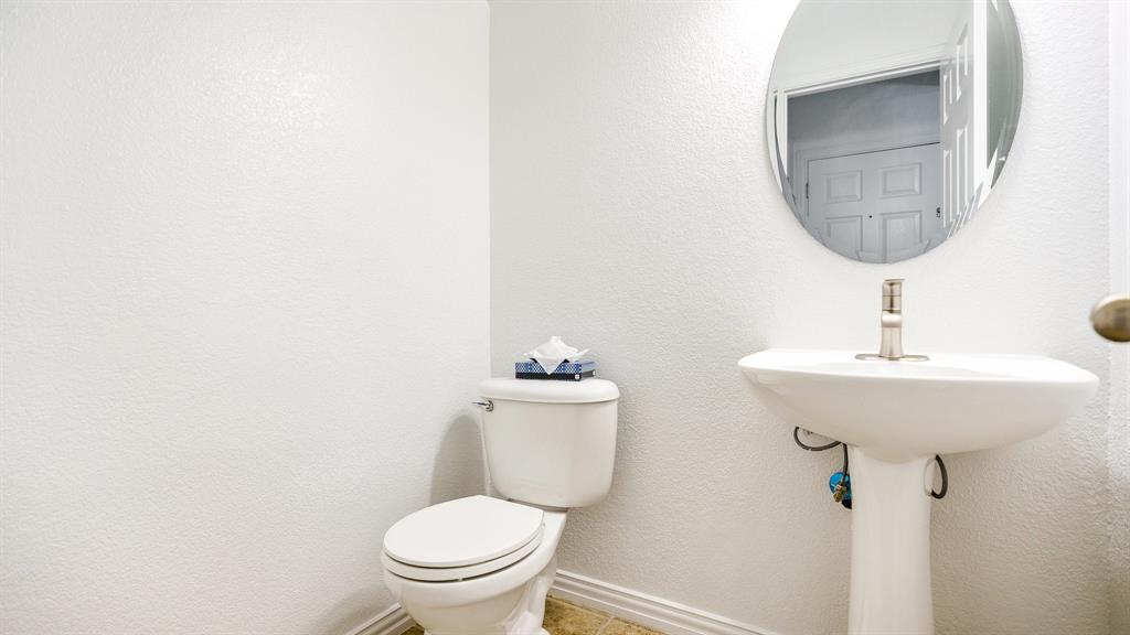 3206 Bedford Road Bedford, TX 76021 - Photo 8 of 26 a bathroom with a toilet sink and mirror