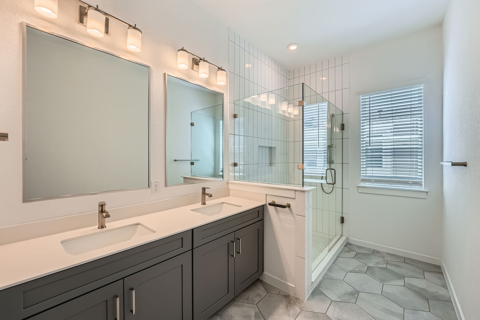 3213 Zach Scott Street Austin, TX 78723 - Photo 15 of 28 Full bathroom featuring double vanity, a sink, a stall shower, and tile patterned floors