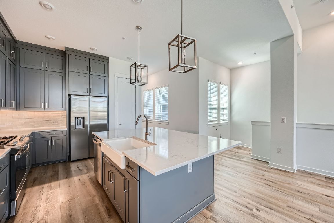 3213 Zach Scott Street Austin, TX 78723 - Photo 20 of 28 Kitchen featuring light quartz countertops, stainless steel appliances, and light wood finished floors