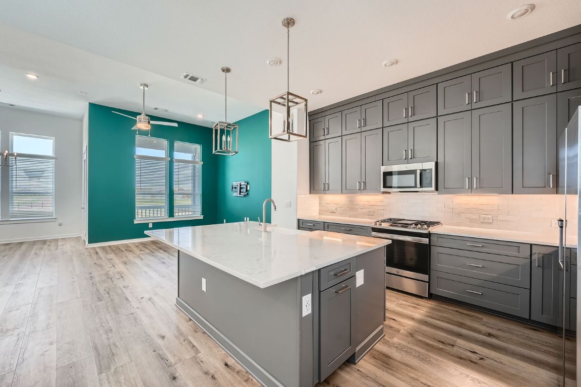 3213 Zach Scott Street Austin, TX 78723 - Photo 21 of 28 Kitchen with backsplash, gray cabinets, stainless steel appliances, and visible vents