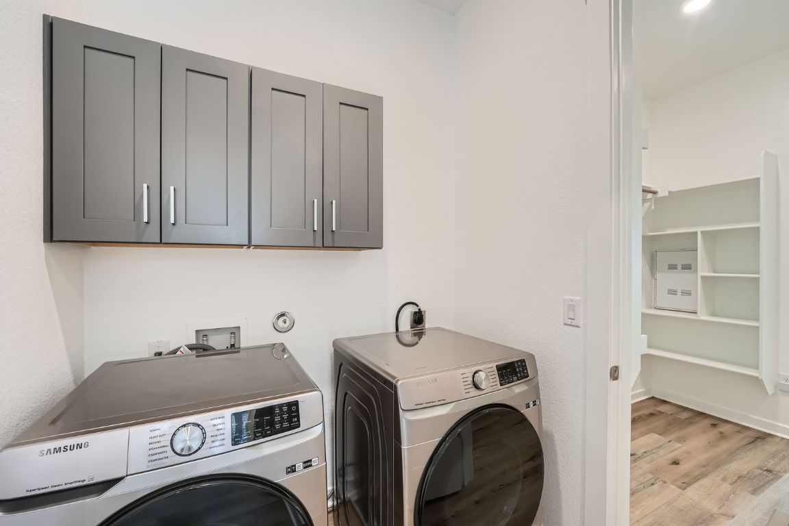 3213 Zach Scott Street Austin, TX 78723 - Photo 23 of 28 Laundry room with cabinet space, light wood-style flooring, and independent washer and dryer