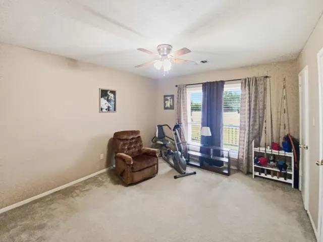 a living room with furniture gym equipment and a large window