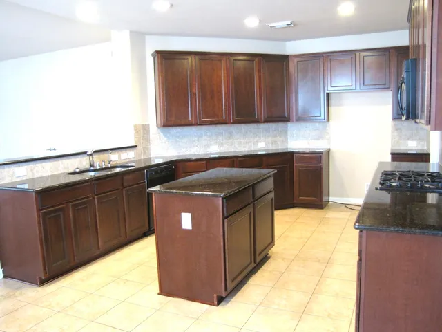 a kitchen with wooden cabinets and a stove top oven