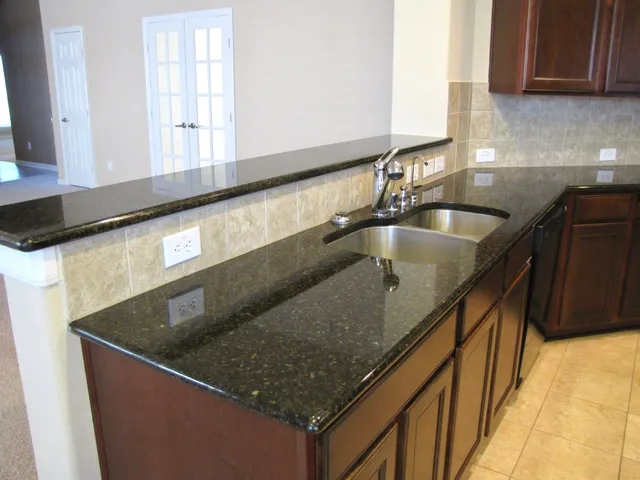 a kitchen with granite countertop a sink and a stove