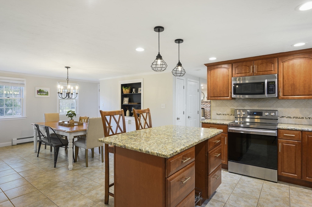 31 Indian Trail Hanson, MA 02341 - Photo 6 of 41 a kitchen with a stove a sink a dining table and chairs
