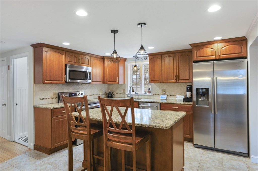 31 Indian Trail Hanson, MA 02341 - Photo 7 of 41 a kitchen with stainless steel appliances granite countertop a stove a refrigerator a kitchen island a cabinets and chairs