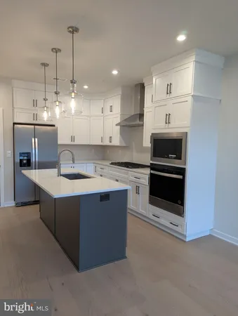 a large kitchen with kitchen island a sink stainless steel appliances and cabinets