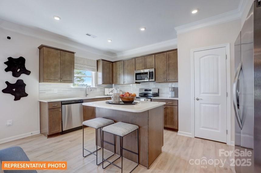 6416 Busch Way Locust, NC 28097 - Photo 9 of 25 a kitchen with stainless steel appliances granite countertop a stove a sink a refrigerator and a microwave