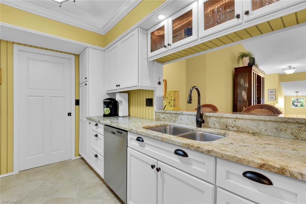 780 Willowbrook Drive, Unit 707 Naples, FL 34108 - Photo 11 of 36 a kitchen with stainless steel appliances granite countertop a sink and cabinets