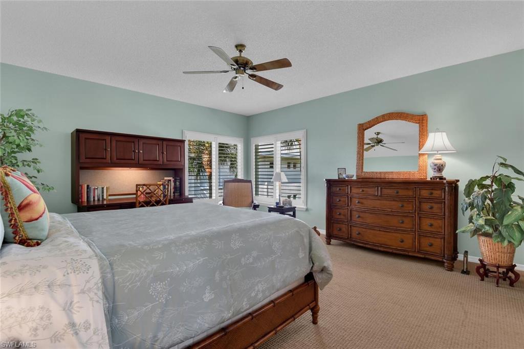 780 Willowbrook Drive, Unit 707 Naples, FL 34108 - Photo 16 of 36 a bedroom with a bed and a chandelier