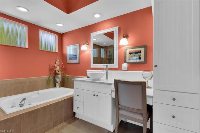 a bathroom with a tub a sink and mirror
