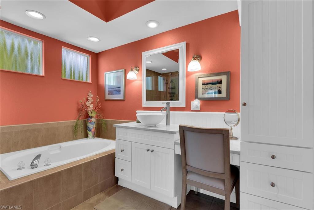 780 Willowbrook Drive, Unit 707 Naples, FL 34108 - Photo 19 of 36 a bathroom with a tub a sink and mirror