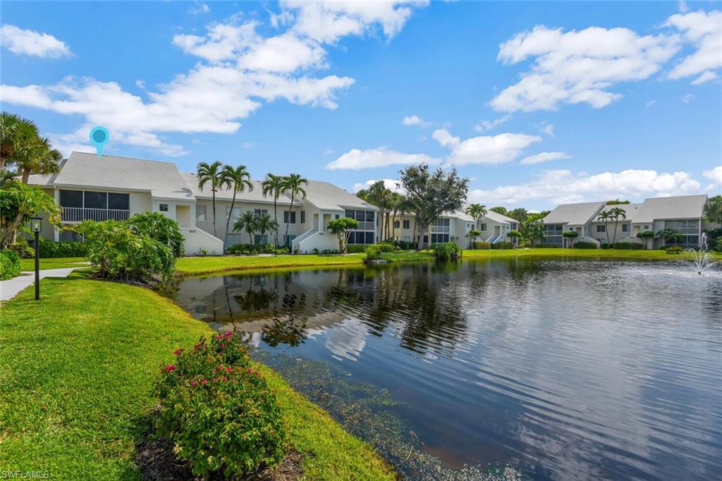 780 Willowbrook Drive, Unit 707 Naples, FL 34108 - Photo 2 of 36 a view of a lake with a house in the background