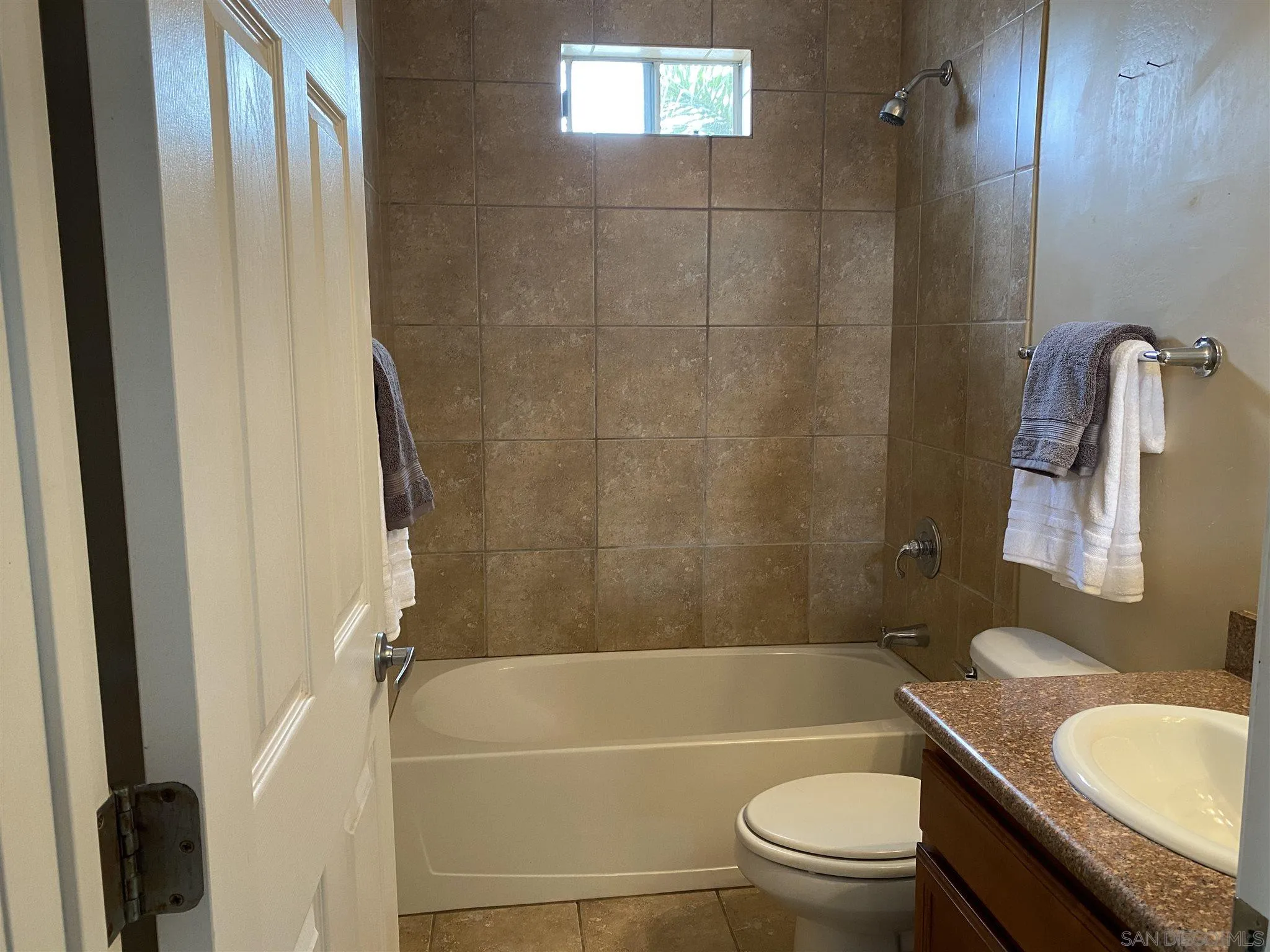 5722 Riley Street, Unit 3 San Diego, CA 92110 - Photo 9 of 14 a bathroom with a granite countertop bathtub shower sink vanity and toilet