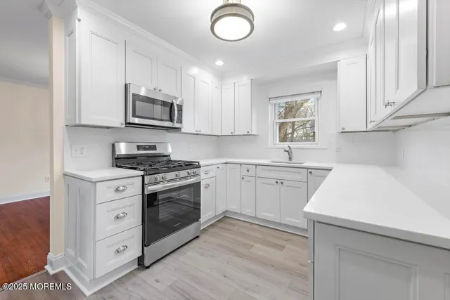 a kitchen with stainless steel appliances white cabinets and a sink